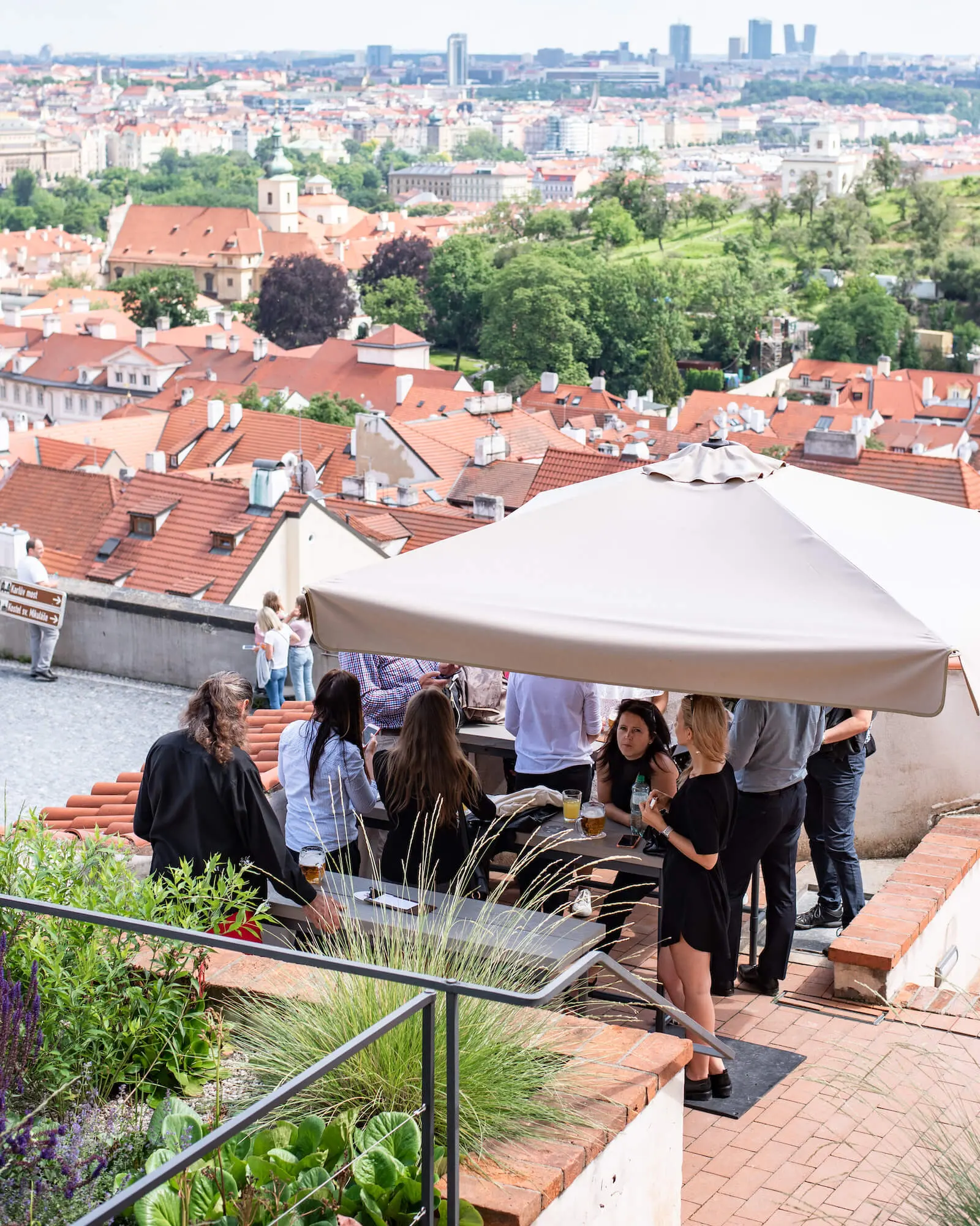Guests gathered at an outdoor table overlooking historic Prague.